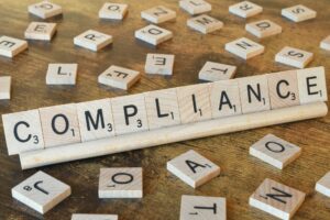 Wooden letter tiles spelling out the word Compliance